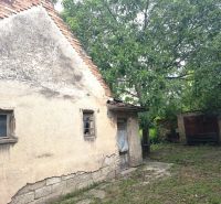 Ein älteres Familienhaus in Nové Zámky, umgeben von Grün, mit beschädigten Wänden.