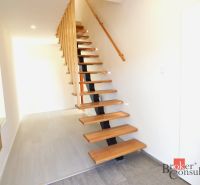 Flur in einer 2-Zimmer-Wohnung mit offener Treppe und Holzboden.