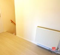 Flur mit Holzboden, Heizkörper und Treppe in einer 2-Zimmer-Wohnung.