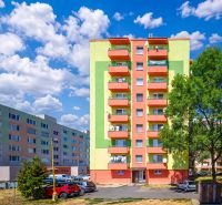 Bunte Wohnhäuser in der Sládkovičova-Straße in Fiľakovo mit Parkplatz und Grünflächen.