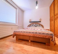Schlafzimmer mit Kleiderschrank und Holzboden in einer Zweizimmerwohnung.