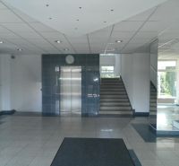 Büros mit Aufzug und Treppenhaus, Spiegel reflektieren das Licht, Fliesenboden.