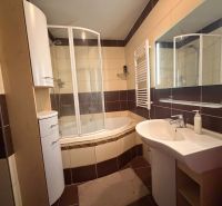 Badezimmer in einer 3-Zimmer-Wohnung mit Badewanne, Dusche, Waschbecken und Möbeln.