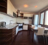 Küche in einer 3-Zimmer-Wohnung mit Holzboden und Esstisch.