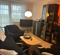 Wohnzimmer in einer 3-Zimmer-Wohnung mit bequemer Sitzecke und Stehlampe.