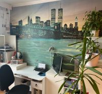 Arbeitsbereich mit Schreibtisch, Pflanzen und dekorativer Tapete in einer 3-Zimmer-Wohnung.
