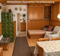Wohnzimmer eines Einfamilienhauses mit Kachelofen und Holzelementen.