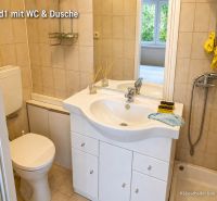 Badezimmer eines Einfamilienhauses mit Waschbecken, WC und Dusche.