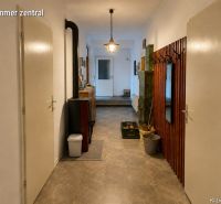 Der Flur in einem Einfamilienhaus mit einer Garderobe, einem Spiegel und einem Ofen, der Boden mit Holzdekor.