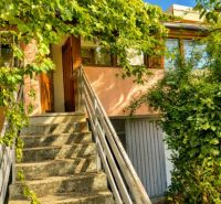 Ein Einfamilienhaus in Illmitz mit Kletterpflanzen, die die Treppe und die Eingangstür umgeben.