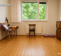 Ein Zimmer in einem Einfamilienhaus mit einem Holzboden und Möbeln.