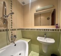 Badezimmer in einer 4-Zimmer-Wohnung mit Badewanne, Waschbecken und Spiegel.