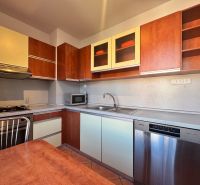 Küche in einer 4-Zimmer-Wohnung mit Geschirrspüler und Küchenzeile mit Holzdekor.