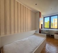 Schlafzimmer in einer 4-Zimmer-Wohnung mit Holzboden und Schreibtisch.
