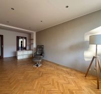 Wohnzimmer in einer 4-Zimmer-Wohnung mit Holzboden und einem bequemen Sessel.