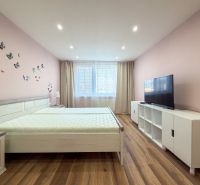 Helles Schlafzimmer mit Schmetterlingen an der Wand und einem Boden mit Holzdekor in einer 2-Zimmer-Wohnung.