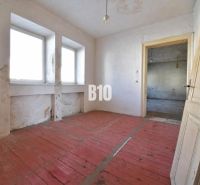 Ein Zimmer in einem Einfamilienhaus mit Holzboden und einfacher Einrichtung.