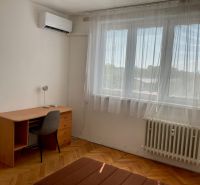 Ein Zimmer in einer 2-Zimmer-Wohnung mit einem Schreibtisch, einem Stuhl und einer Klimaanlage.