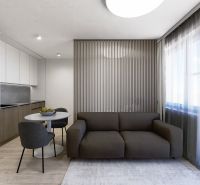 Wohnbereich einer 3-Zimmer-Wohnung mit Sofa und Esstisch, Boden mit Holzdekor.
