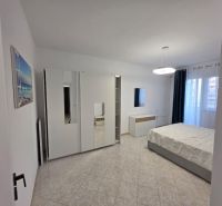 Helles Schlafzimmer in einer 2-Zimmer-Wohnung mit modernen Möbeln und Keramikboden.