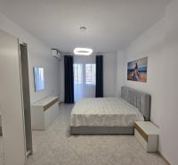 Schlafzimmer in einer 2-Zimmer-Wohnung mit Bett, weißen Möbeln und einem Bild an der Wand.
