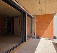 Unvollendete 3-Zimmer-Wohnung in SRIMA mit Glastüren und unverputzten Ziegelwänden.