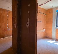 Innenraum einer 3-Zimmer-Wohnung mit Ziegelwänden, im Rohbau.