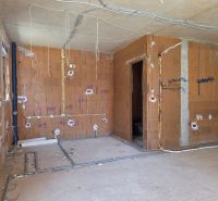 Bau einer 3-Zimmer-Wohnung mit Ziegelwänden und Installation von Leitungen.
