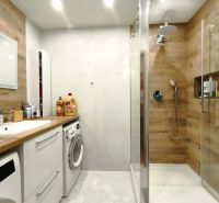 Badezimmer in einer 3-Zimmer-Wohnung, Duschkabine mit Boden in Holzoptik.