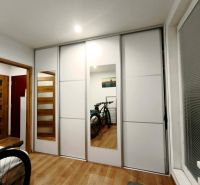Schlafzimmer mit Schrank und Fahrrädern in einer 3-Zimmer-Wohnung; Boden mit Holzdekor.