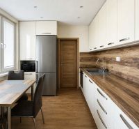 Küche in einer 3-Zimmer-Wohnung mit Boden und Arbeitsplatte in Holzoptik.