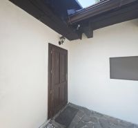 Eingang zur Hütte in Špania Dolina mit Steinterrasse und Holzelementen.