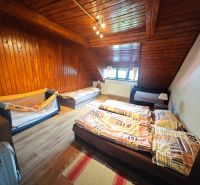 Ein Dachzimmer in einer Hütte mit Holzverkleidung und einem Boden mit Holzdekor.