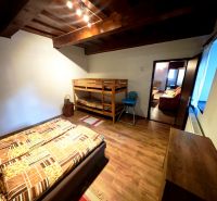 Ein Zimmer in einer Hütte mit einem Etagenbett, einem Boden in Holzoptik und Deckenbalken.