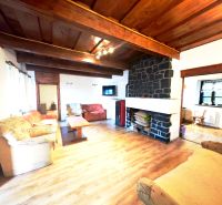 Wohnzimmer in der Hütte mit Kamin, Sofas und Holzboden.