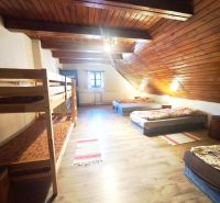 Ein Dachzimmer in einer Hütte mit Betten und einem Boden in Holzoptik.