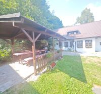 Eine Hütte in Špania Dolina mit einem Pavillon, einem Holztisch und Blumenschmuck im Garten.