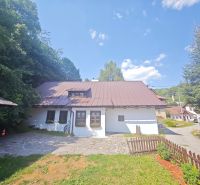 Eine Hütte in Špania Dolina, umgeben von Natur, mit einem steinernen Weg und einem Holzzaun.