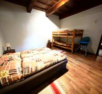 Schlafzimmer in der Hütte mit Doppelbett, Etagenbett und Boden mit Holzdekor.