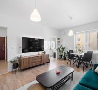 Helles Wohnzimmer einer Zweizimmerwohnung mit Holzboden und Esstisch.