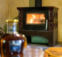 Wohnzimmer mit Holzbalkendecke, Sofa und Holzboden in einer Hütte.