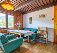 Innenraum der Hütte mit Retro-Möbeln und Holzboden, bequeme Sessel, Vintage-Radio.