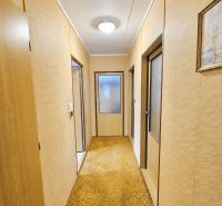 Der Flur in einem Einfamilienhaus mit einem beigen Teppich und Holztüren.