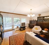 Wohnzimmer in einem Einfamilienhaus mit Teppichboden, Möbeln und Fernseher.