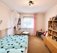 Izba eines Familienhauses mit Bett, Bücherregal und bunten Accessoires.