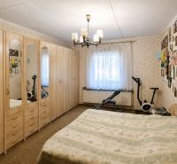 Schlafzimmer in einem Einfamilienhaus mit großem Schrank, Bett und Fitnessgeräten.
