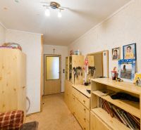 Innenraum eines Einfamilienhauses mit Holzmöbeln, Teppich und Fotos an der Wand.