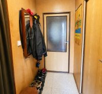 Flur in einem Einfamilienhaus mit Kleiderständer und Schuhschrank, neutrale Farbtöne.
