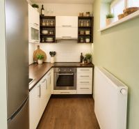 Küche in einer Einzimmerwohnung mit Holzboden und eingebauten Geräten.