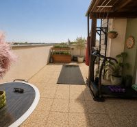 Eine Terrasse mit Fliesen, Pflanzen und Fitnessgeräten in einer Einzimmerwohnung in der Kirschstraße in Chorvátsky Grob.